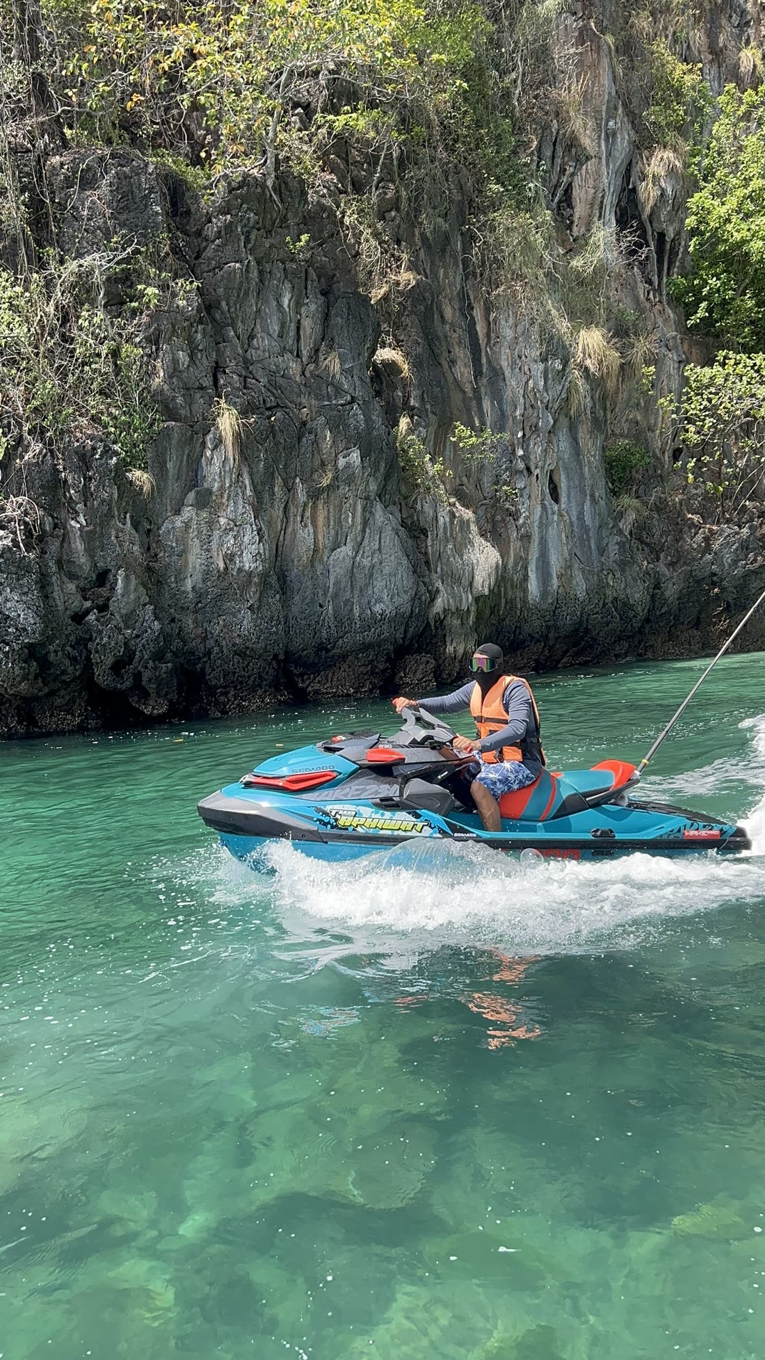 A rider speeding past a limestone cliff